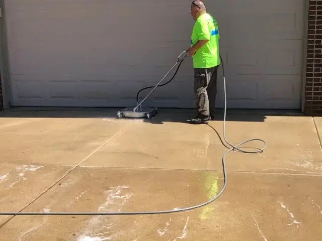 rob cobb pressure cleaning a customer's driveway.